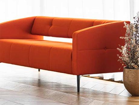 Orangefarbenes Sofa mit Pflanze